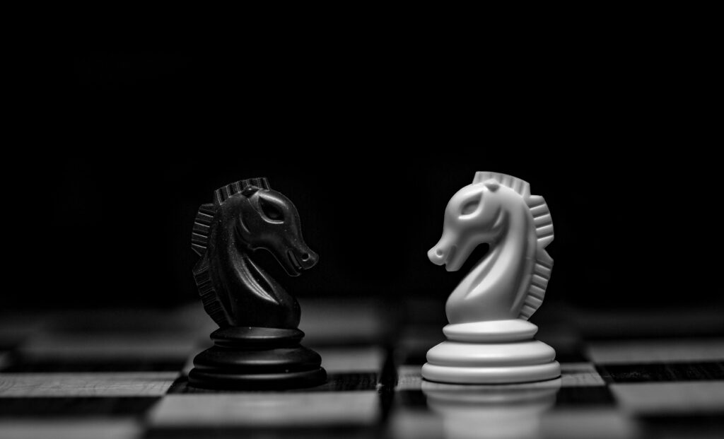 Two chess pieces facing off on a chess board