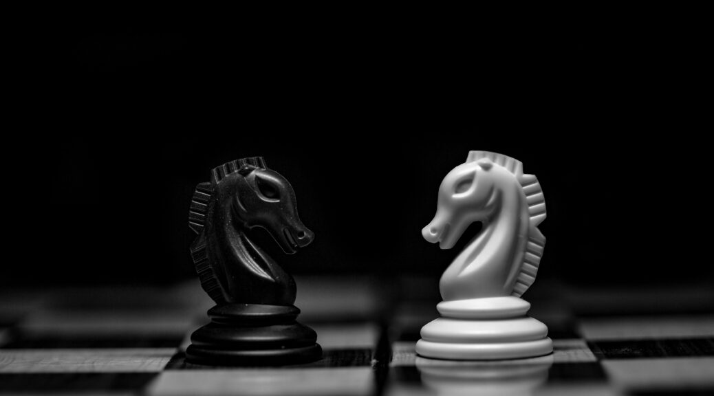 Two chess pieces facing off on a chess board