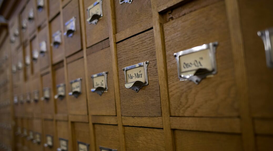 Old fashioned wooden card catalog drawers with metal label holders
