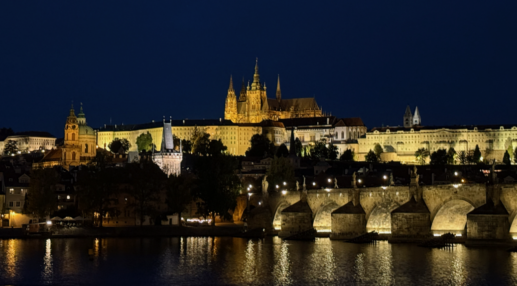 View of the Prague Castle lit up at night from across the river.